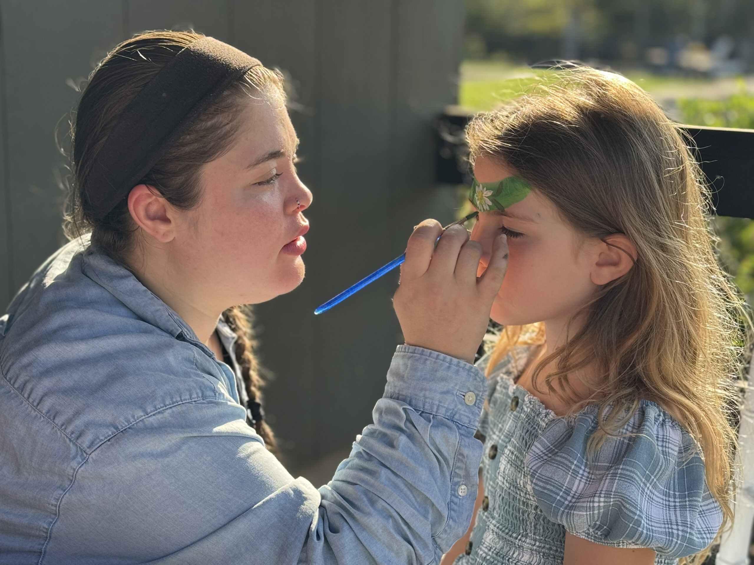 Alexis face painting and balloon twisting at an outdoor event in CT