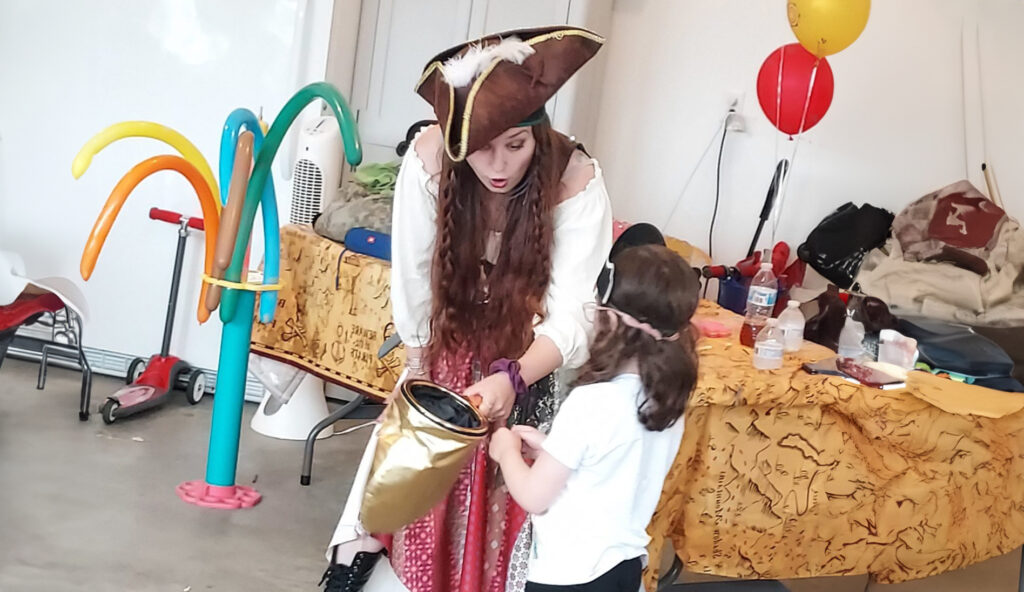 Lexi the pirate performing a magic show with balloon twister supplies visible in the background at a CT birthday party